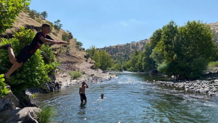 Derecik'te 40 derece ulaşan sıcaktan bunalan gençler çayda serinleniyor